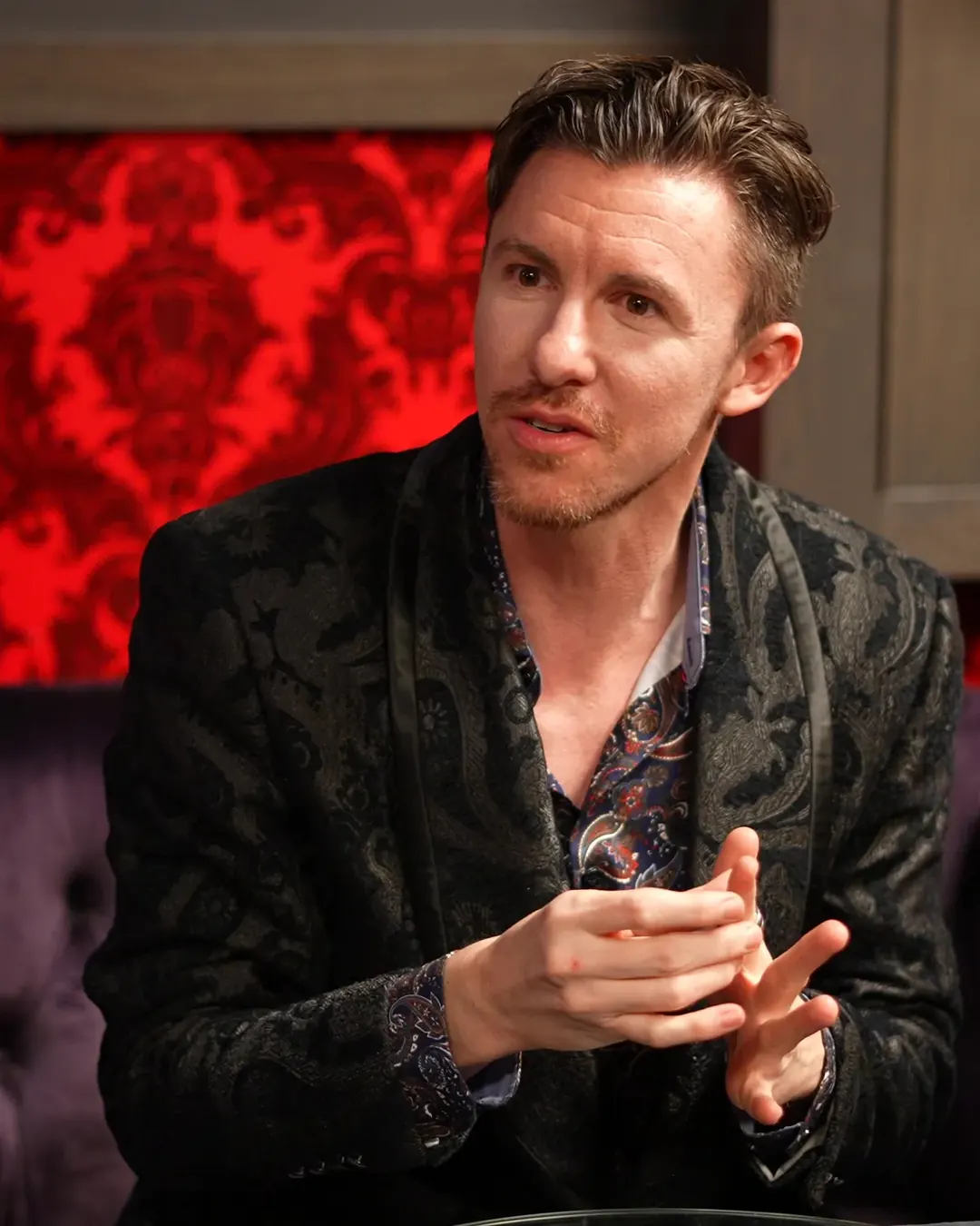 Stefan Oswald listening and talking with someone across a table