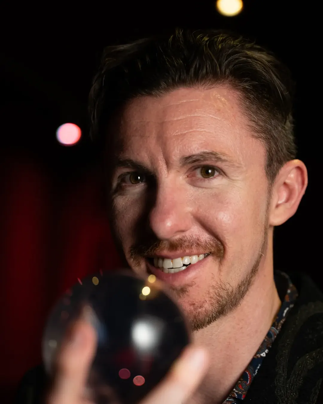 Stefan Oswald holding a crystal ball close to the camera