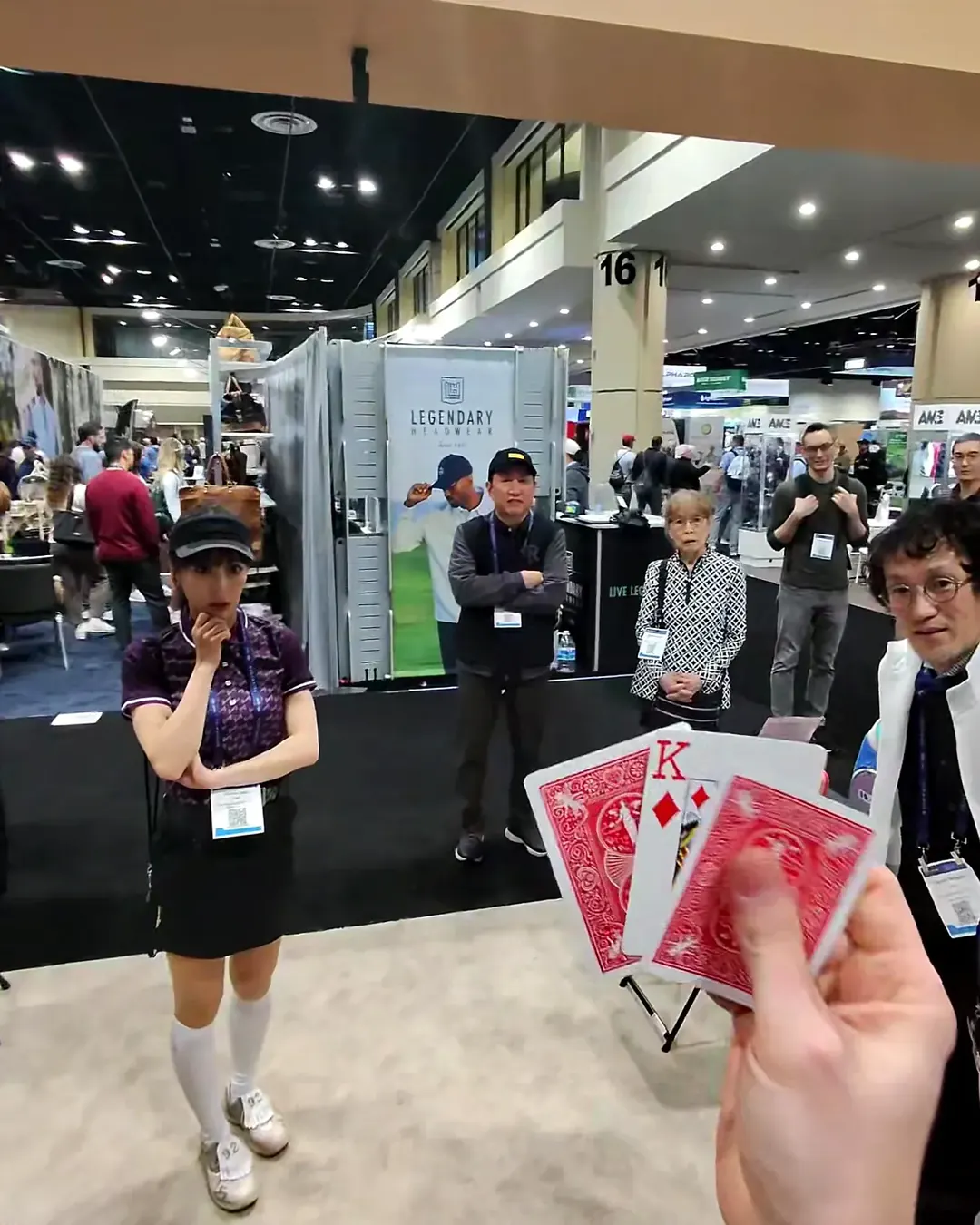 A crowd at a trade show booth reacting to a card reveal